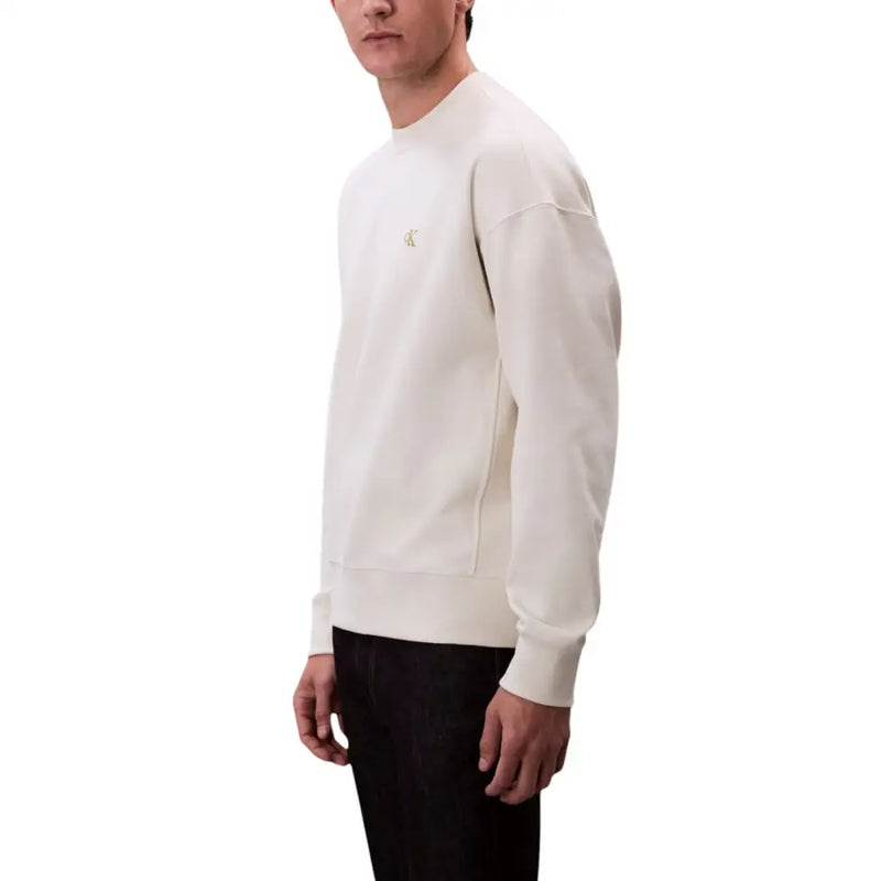 Beige crewneck sweatshirt in cream color featuring a subtle gold Calvin Klein logo on the chest