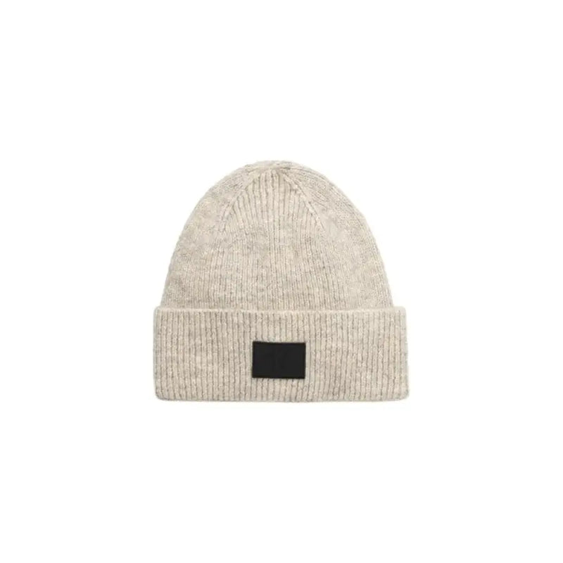 Beige knit beanie featuring a stylish black patch for contemporary accessory appeal