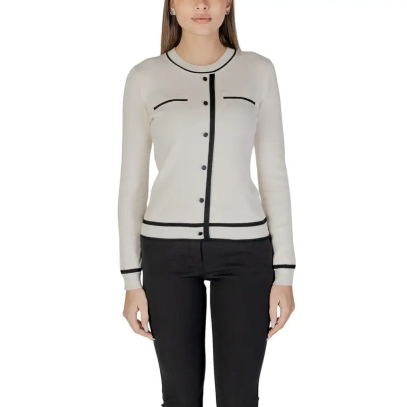 Beige long sleeve knit cardigan with front pockets made of cream-colored knit with black trim on neckline and cuffs