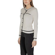 Beige long sleeve knit cardigan with front pockets in off-white with black trim on neckline button placket and cuffs