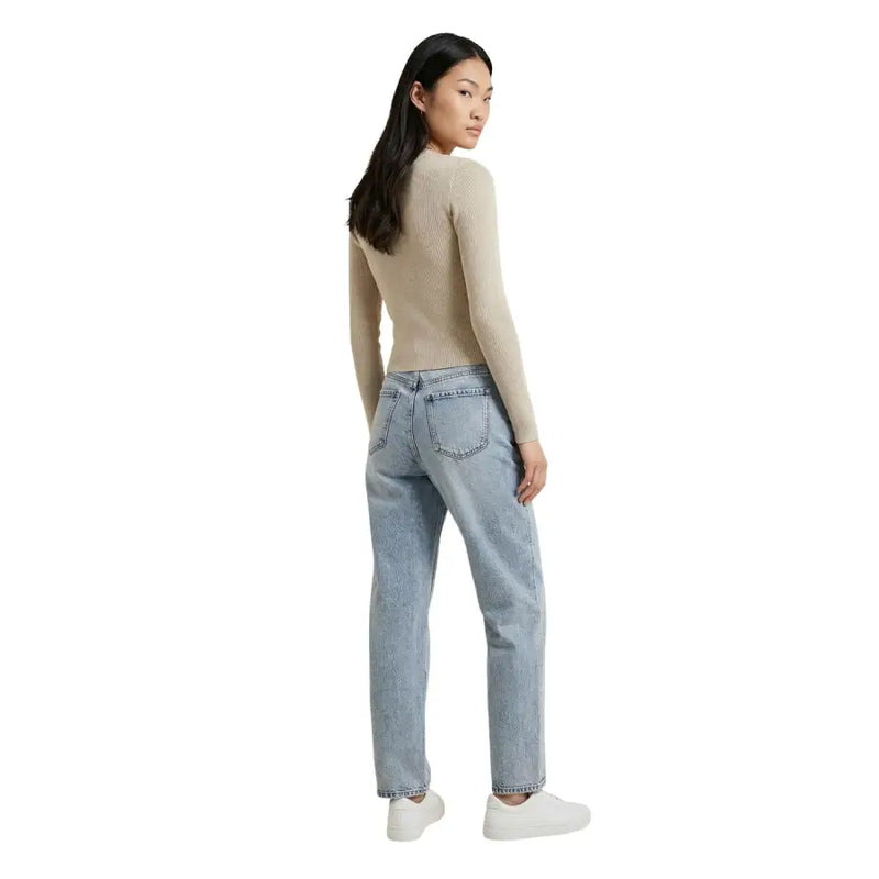 Beige long sleeve v neck button cardigan for women paired with light-wash denim jeans with a relaxed straight-leg cut