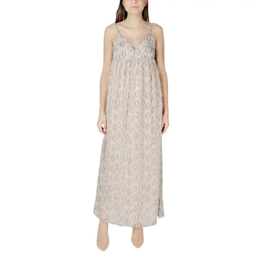Beige patterned sleeveless maxi dress featuring flowing lace fabric with delicate spaghetti straps and a v-neckline