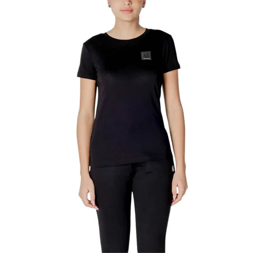 Black crewneck t shirt made of cotton featuring a black short-sleeved design with a small rectangular logo patch on the chest