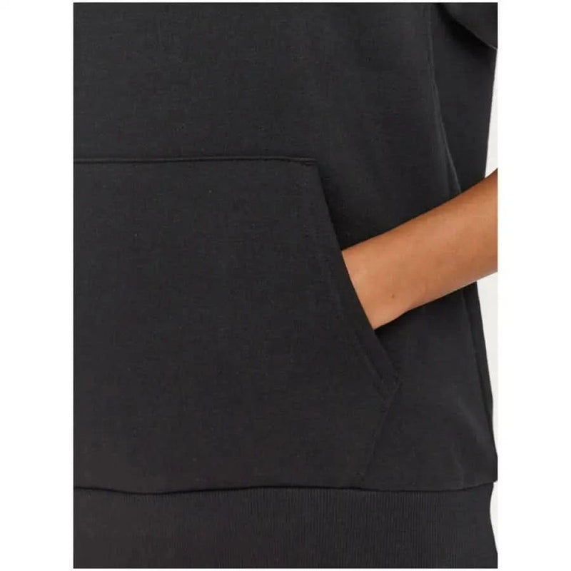 Hand in pocket of Under Armour Women’s Black Hooded Sweatshirt with Pockets