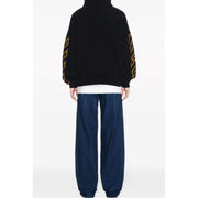 Black oversized hoodie with yellow geometric patterns along the sleeves in a comfortable casual design