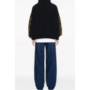Black oversized hoodie with yellow geometric patterns along the sleeves in a comfortable casual design