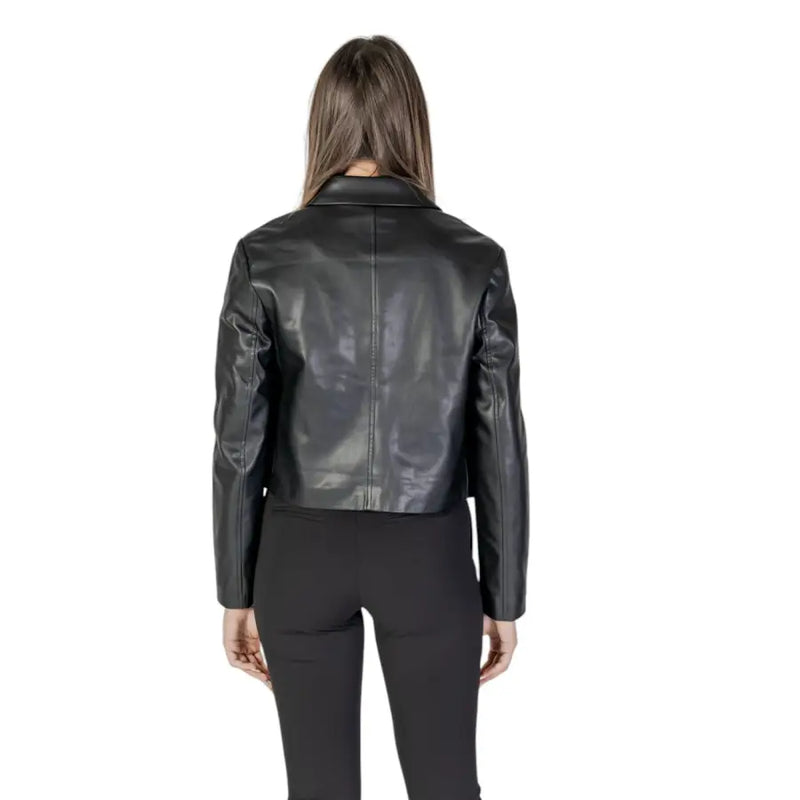 Schwarze Leder-Motorradjacke mit elegantem, glänzendem Finish und klassischem Kragen, kombiniert mit einem langen, schwarzen Polyurethan-Blazer mit Vordertaschen.