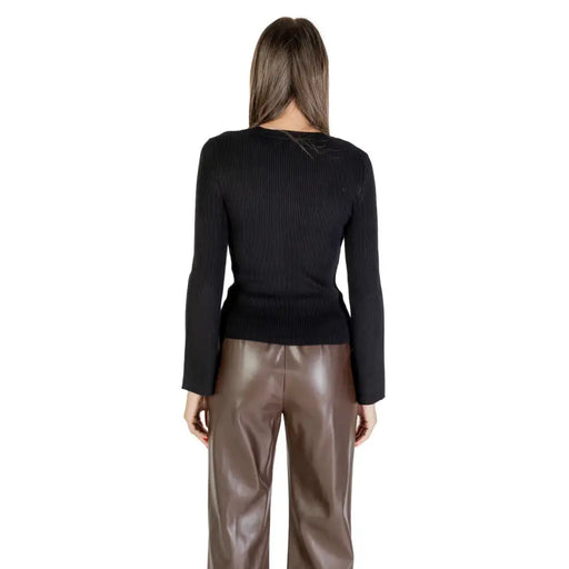 Black long round neck women knit sweater with rhinestones paired with brown faux leather pants