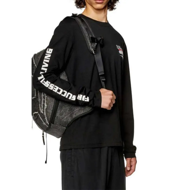 Black long sleeved shirt with white sleeve text shown beside a black backpack with gray textured panels and white lettering