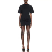 Black short-sleeved mini dress with high neckline and gathered waist detail paired with sculptural heels