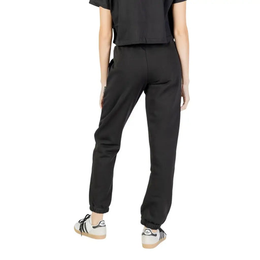 Black Adidas joggers for women with elastic cuffs, laces, and side pocket