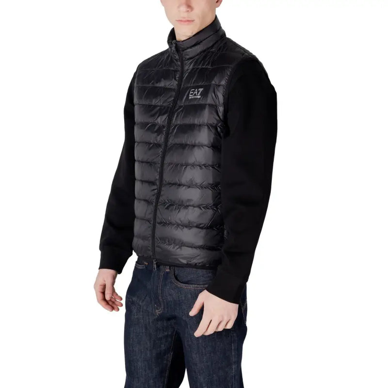 Black quilted puffer vest with high collar, zipper front, knit sleeves, and ea7 logo on the chest