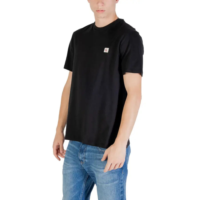Black short sleeve crewneck t-shirt made of cotton with a small white Calvin Klein logo patch on the left chest