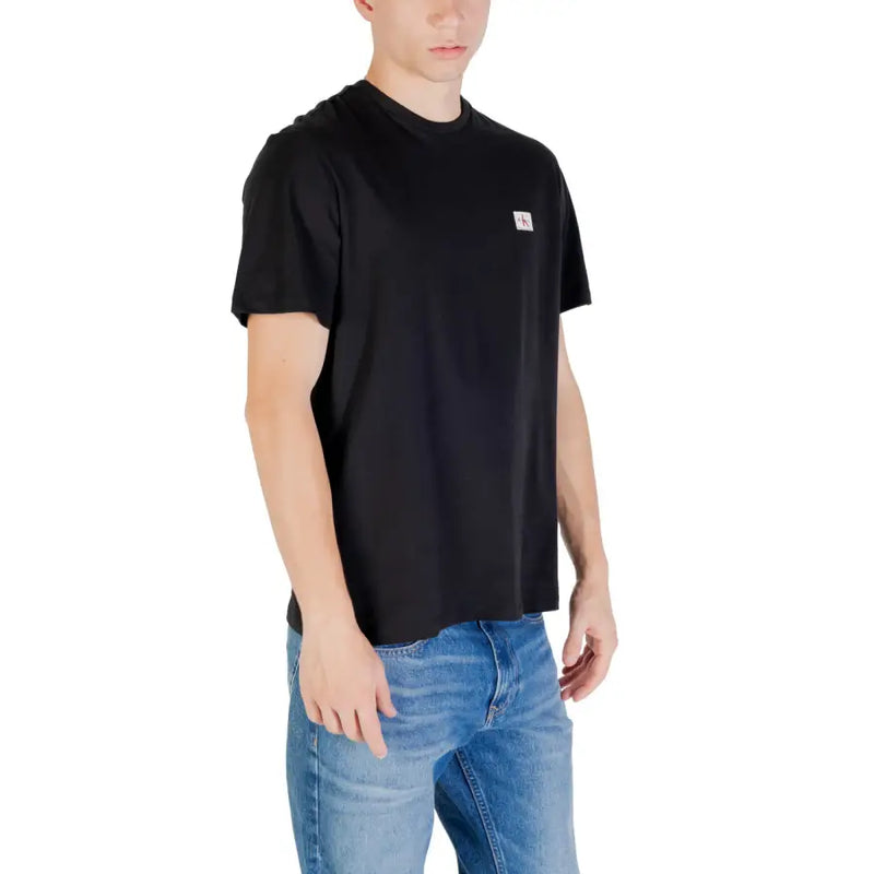 Black short sleeve crewneck t-shirt made of cotton with a small white Calvin Klein logo patch on the left chest
