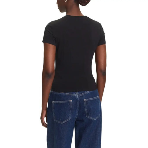 Black short-sleeved organic cotton T-shirt paired with dark wash loose denim jeans