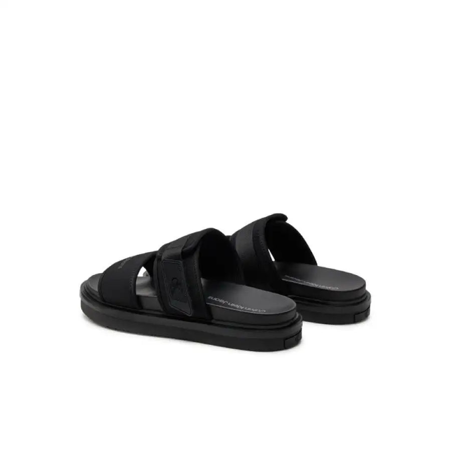 
                      
                        Calvin Klein Jeans Men Sandals - sleek black slip on a white background
                      
                    