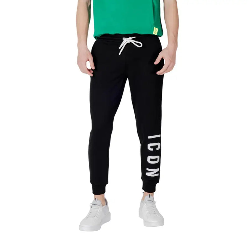 Black sweatpants with white drawstring featuring vertical icon lettering on the left leg made from soft fabric