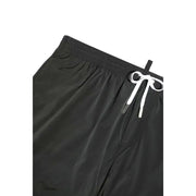 Black swim trunks with a white drawstring featuring metallic aglets and the icon dsquared2 logo on black fabric