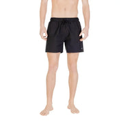 Black swim trunks displayed in a product image for men’s swimwear
