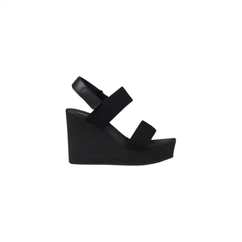 Black wedge sandal displayed in the product image showcasing stylish footwear