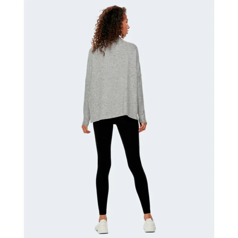 A soft heather gray oversized knit sweater with long sleeves paired with black women’s leggings for fall and winter