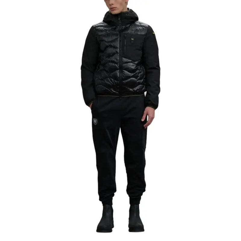 Black quilted down vest with hood and zipper closure, monogrammed logo on sleeve.