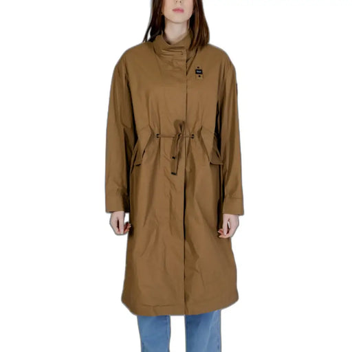 A tan mid-length trench coat with high collar and drawstring waist in 100% cotton for spring summer wear