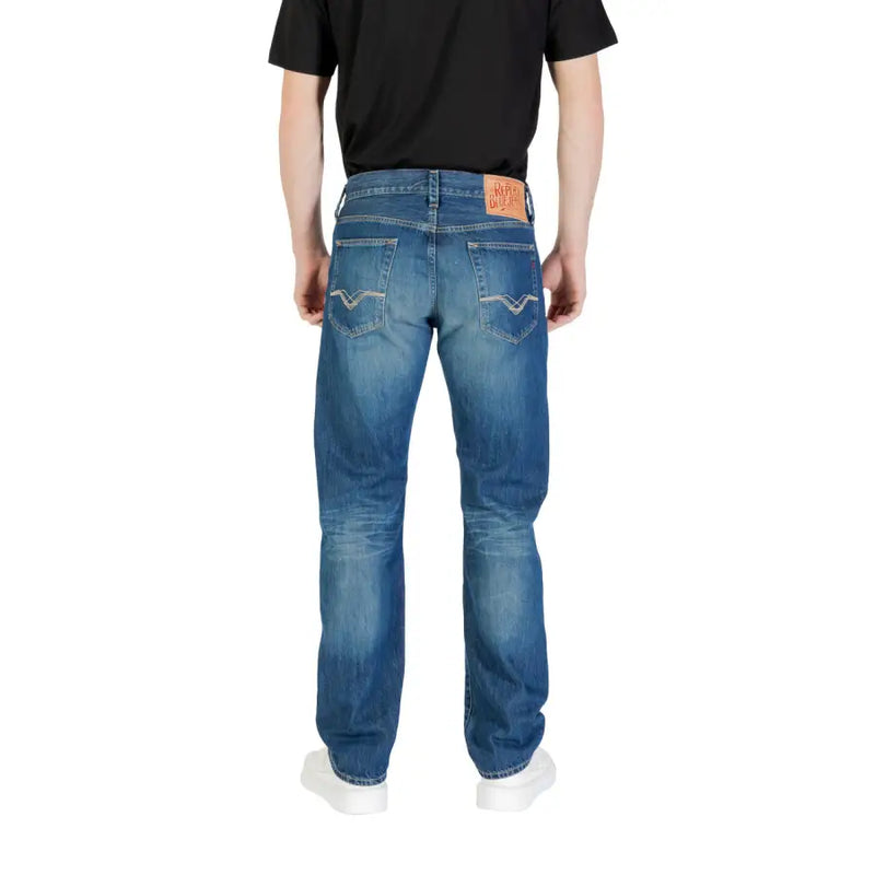 Blue denim jeans back side with faded wash, white stitching on pockets, and orange leather brand patch at waistband