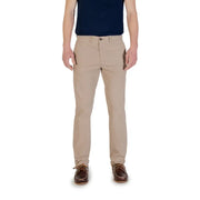 Men’s beige chino trousers paired with navy polo shirt and brown boat shoes for spring summer fashion