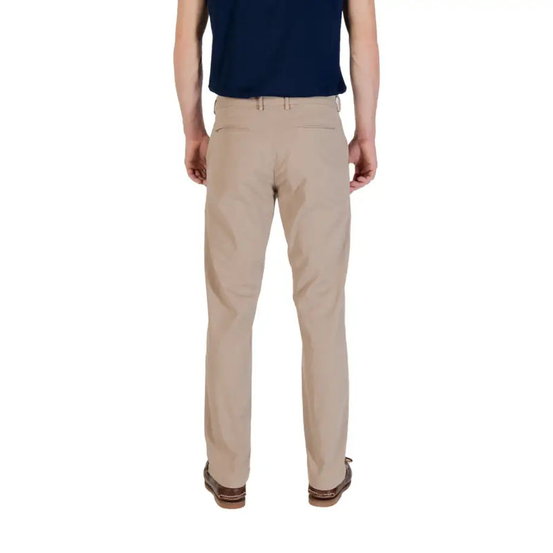Men’s beige cotton elastane chinos paired with navy polo shirt and boat shoes for spring summer style