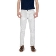 Men’s white chino pants paired with a dark blue t-shirt and brown boat shoes