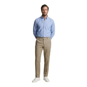 A man wearing borghese men trousers camel 100% linen paired with a light blue button-down shirt spring summer attire