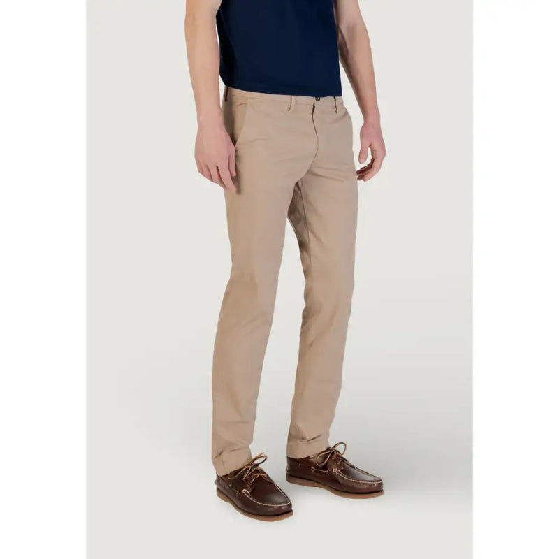 Men’s beige cotton stretch chinos paired with brown boat shoes for a stylish look
