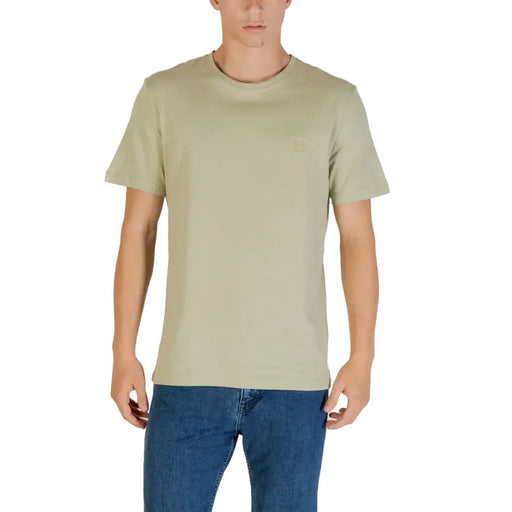 Man modeling a light green Crewneck T-shirt and blue jeans for Boss Men beige short sleeve round neck cotton T shirt