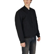 Veste blazer noire zippée pour homme, en coton polyamide, au design minimaliste et élégant, avec des détails de couture discrets.