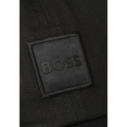 Black textured fabric patch with embossed boss logo stitched on dark woven material of boss men cap 100% cotton