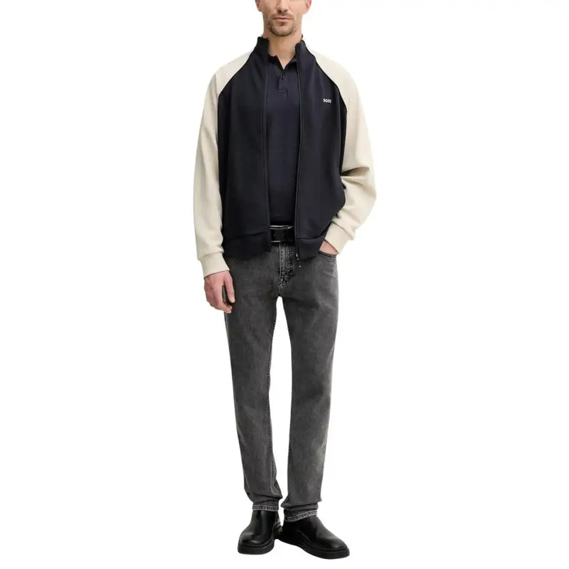 Bomberjacke in Marineblau und Creme mit Colorblock-Design, Reißverschluss vorne und dezentem Logo, kombiniert mit grauen Boss Men Jeans aus Baumwollstretch in schmaler Passform.