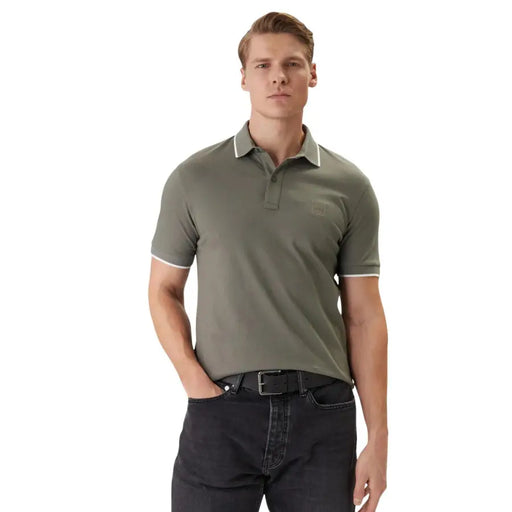 Boss Herren-Poloshirt, kurzärmelig, aus olivgrünem Baumwoll-Elastan mit weißem Besatz an Kragen und Ärmelbündchen.