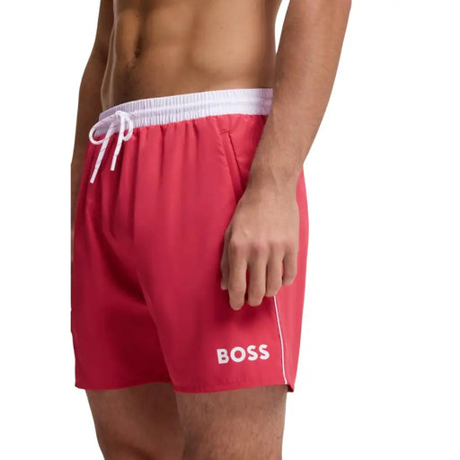 Bright red Boss men swim trunks with white elastic waistband and drawstring featuring bold white logo on lower left leg