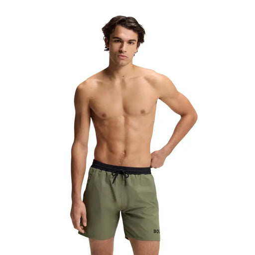 Olive green polyester Boss men swimwear trunks with black drawstring waistband and subtle side brand logo with pockets
