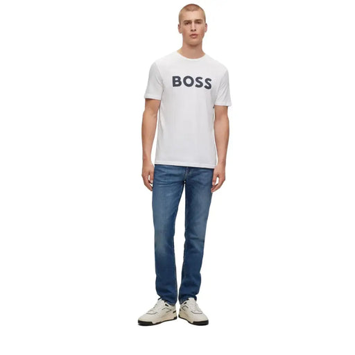 Man modeling Boss Men White Logo Print Round Neck Cotton T Shirt with blue jeans and white sneakers