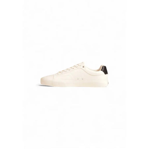 White leather low-top sneaker with black accents and logo.