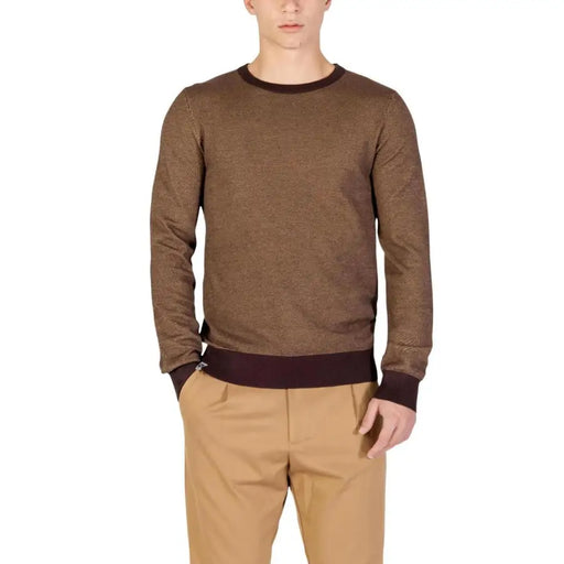 Brown textured sweater with ribbed cuffs and hem, likely made of cotton or wool.