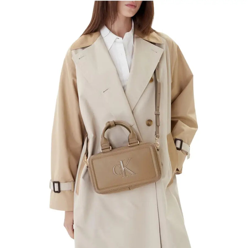 Beige leather Calvin Klein zippered womens handbag with prominent CK logo measuring 22 by 12.5 by 7 centimeters