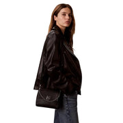 Calvin Klein black polyurethane leather crossbody handbag with silver chain shoulder strap and logo clasp
