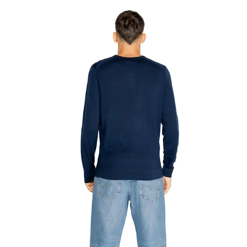 Navy blue crew neck sweater with ribbed cuffs and hem, likely made of cotton or a similar soft material.
