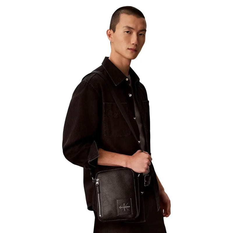 Calvin Klein Bold Pebble Crossbody-Tasche für Damen aus schwarzem, strukturiertem Leder mit silbernem Logo-Emblem, Vorderansicht