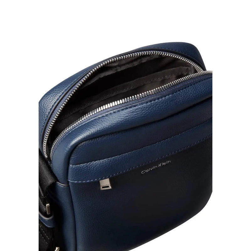 Calvin Klein Umhängetasche „Raised Reporter“ für Damen aus dunkelblauem Leder mit silbernem Reißverschluss und dezenten Ziernähten, Vorderansicht