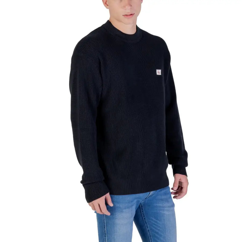 Calvin Klein Jeans black cotton ribbed knit sweater with small white logo patch on the left chest