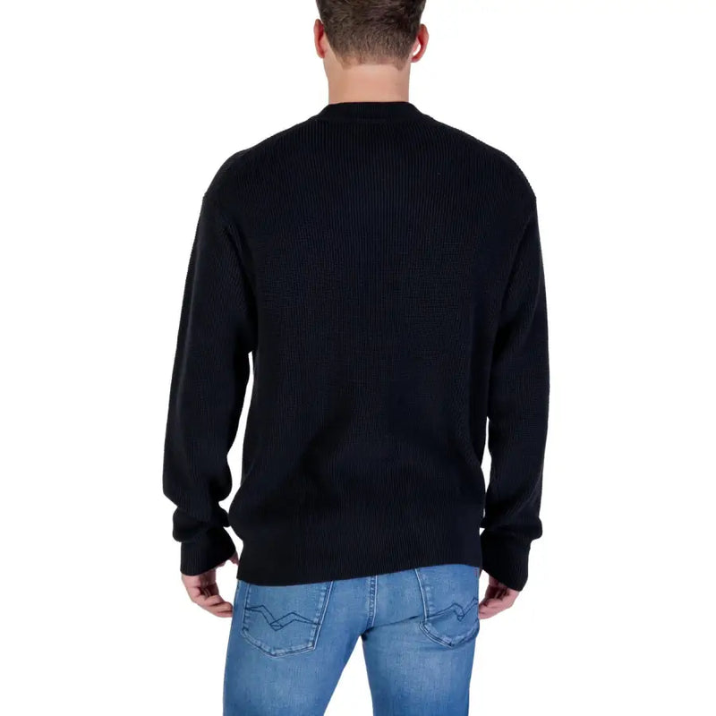 Black ribbed crew neck sweater with jeans and a casual look.